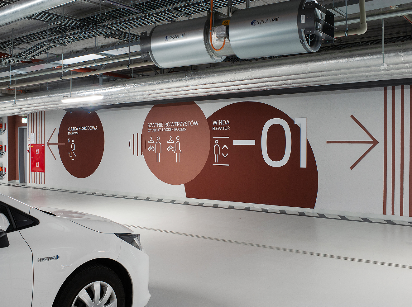 Garage wall graphics marking level -01 with pictograms and a direction arrow