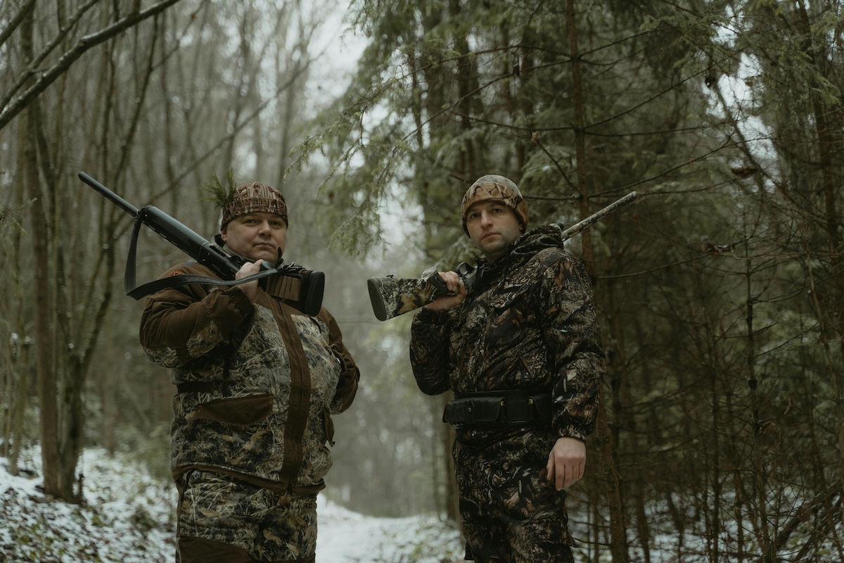 Two Hunters Stand on Forest Holding Rifles