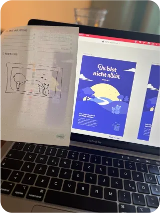 Foto, auf dem ein Laptop zu sehen ist, an dem die Entwürfe für das Pathly-Magazin erstellt wurden. Auf der linken Seite des Laptops klebt außerdem ein Zettel mit einer Entwurfszeichnung der Illustration für das Cover. Die Illustration für das Cover ist ein Pfad, der über einen Hügel verläuft.