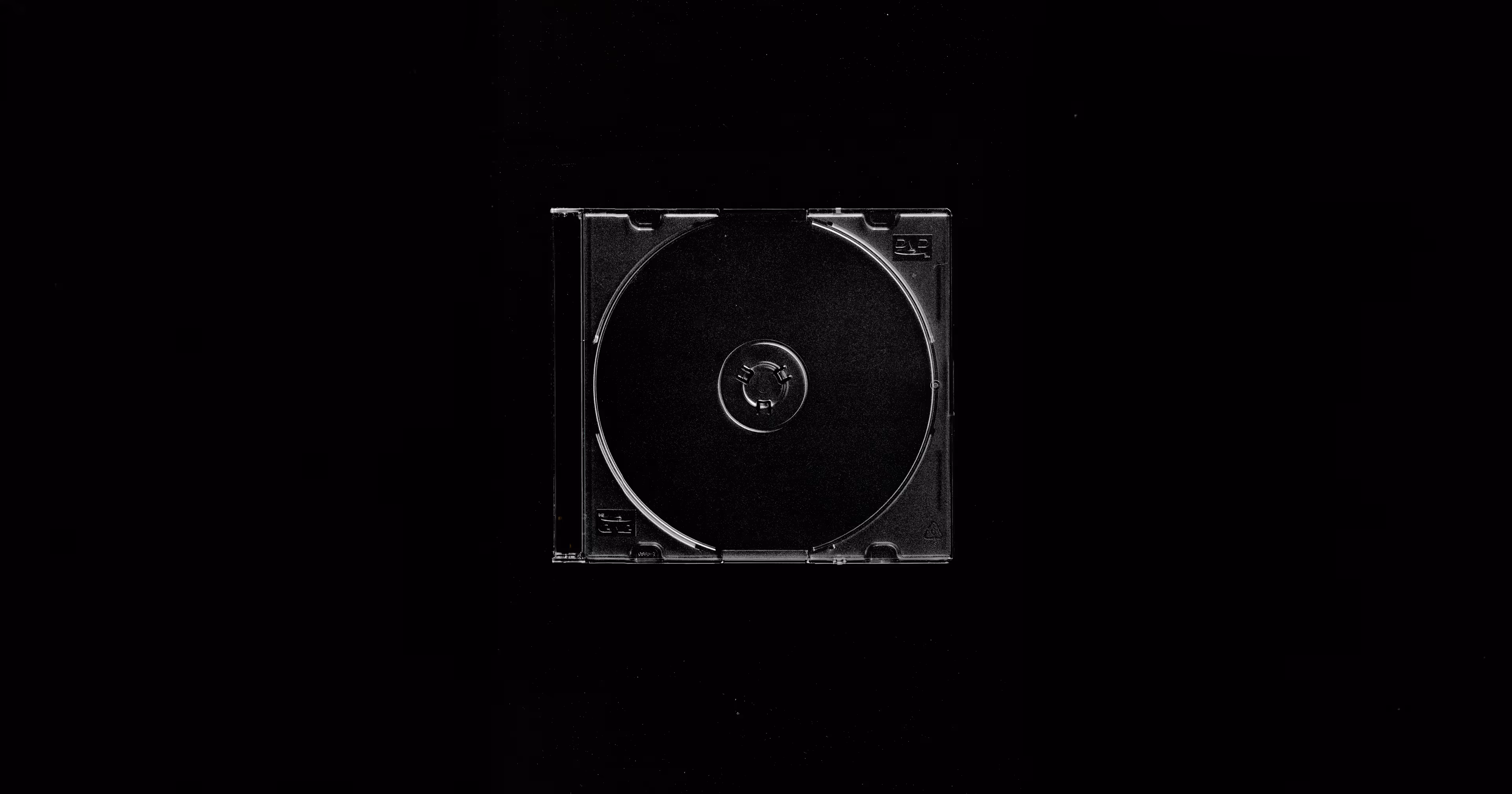Empty transparent plastic CD case centered on black background.