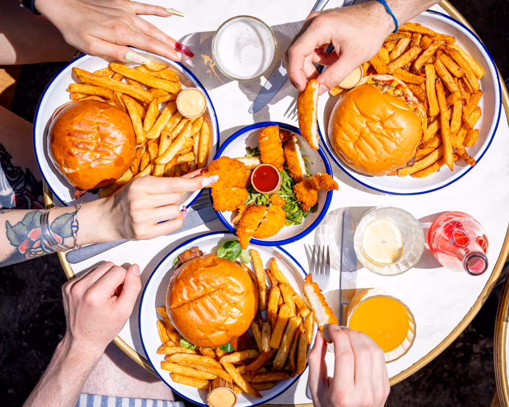 Belle tablée avec des burgers des frites des croustillants de poulet au restaurant des Burgers de Colette du Cap Ferret Claouey