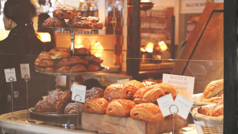 Vitrina repleta de repostería francesa clásica como croissants y pain au chocolat, ideal para aprender comida en francés.