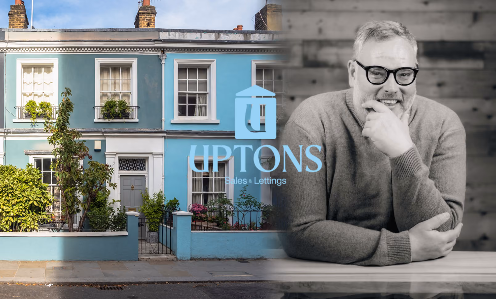 a man sitting at a table in front of a blue building