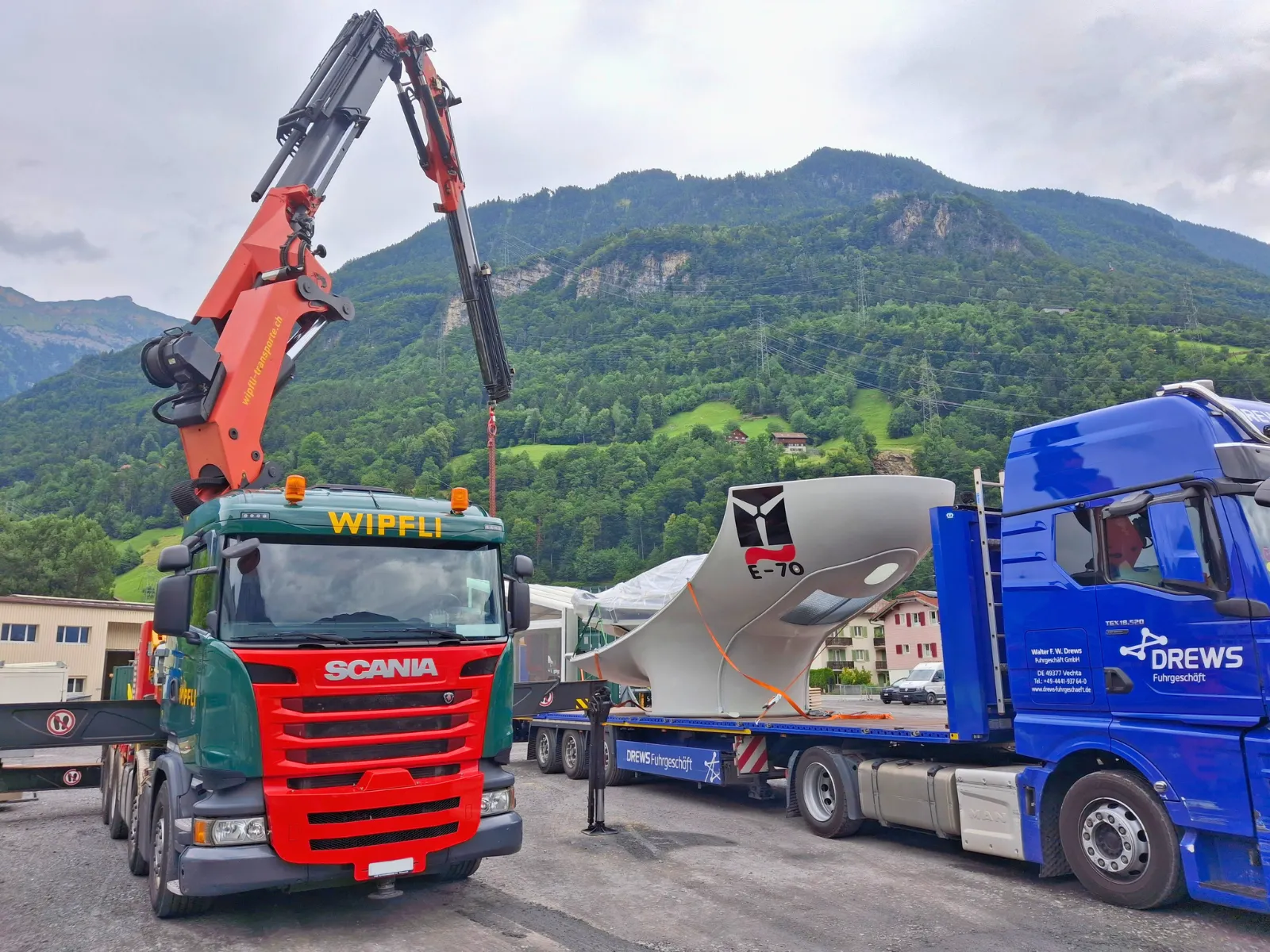 Lastwagen LKW, Chauffeur welche mit einem Kran ein Windkraftwerk installieren.
