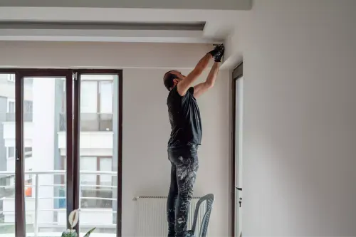 Photograph of a man painting the interior of a home