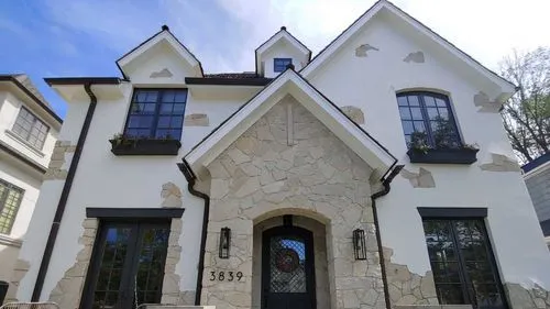 A photograph of an exterior home with paint and stone