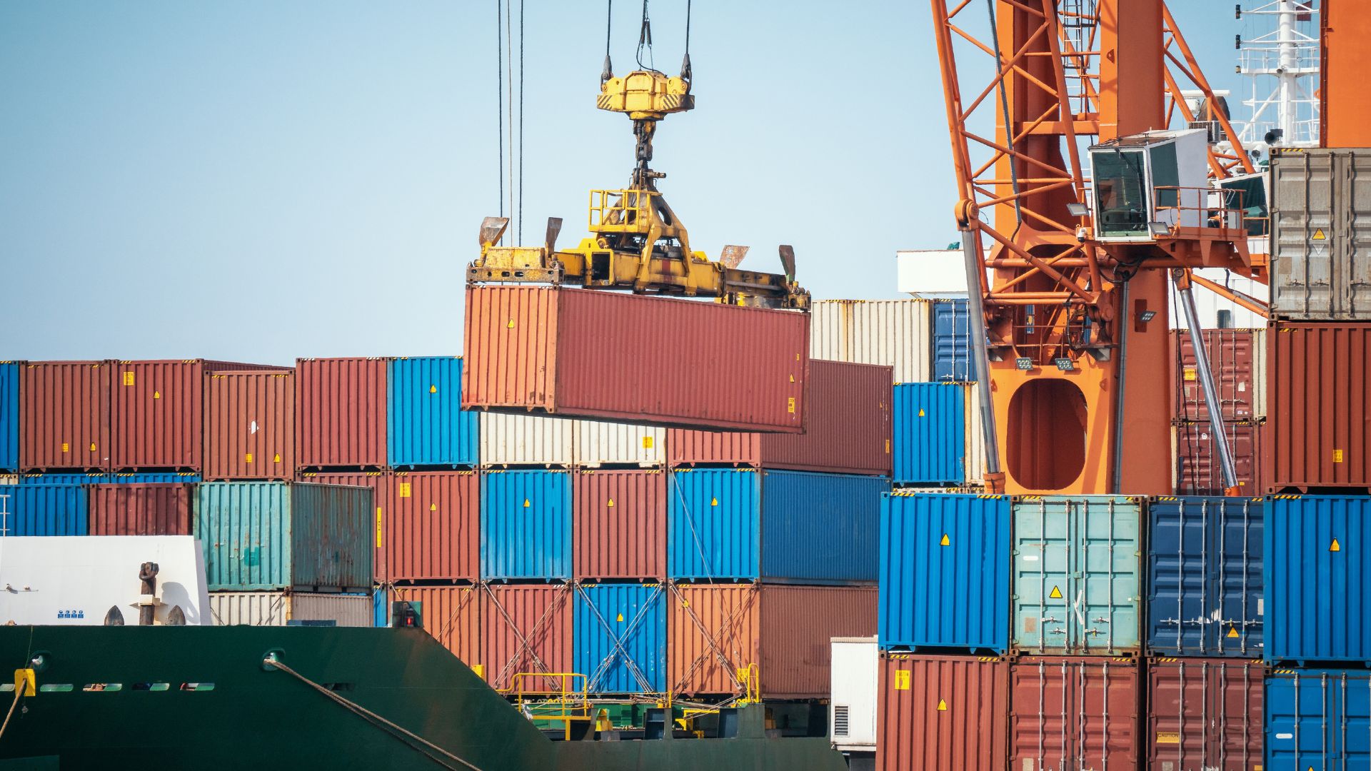 A container being lifted up by a crane off a ship to the terminal