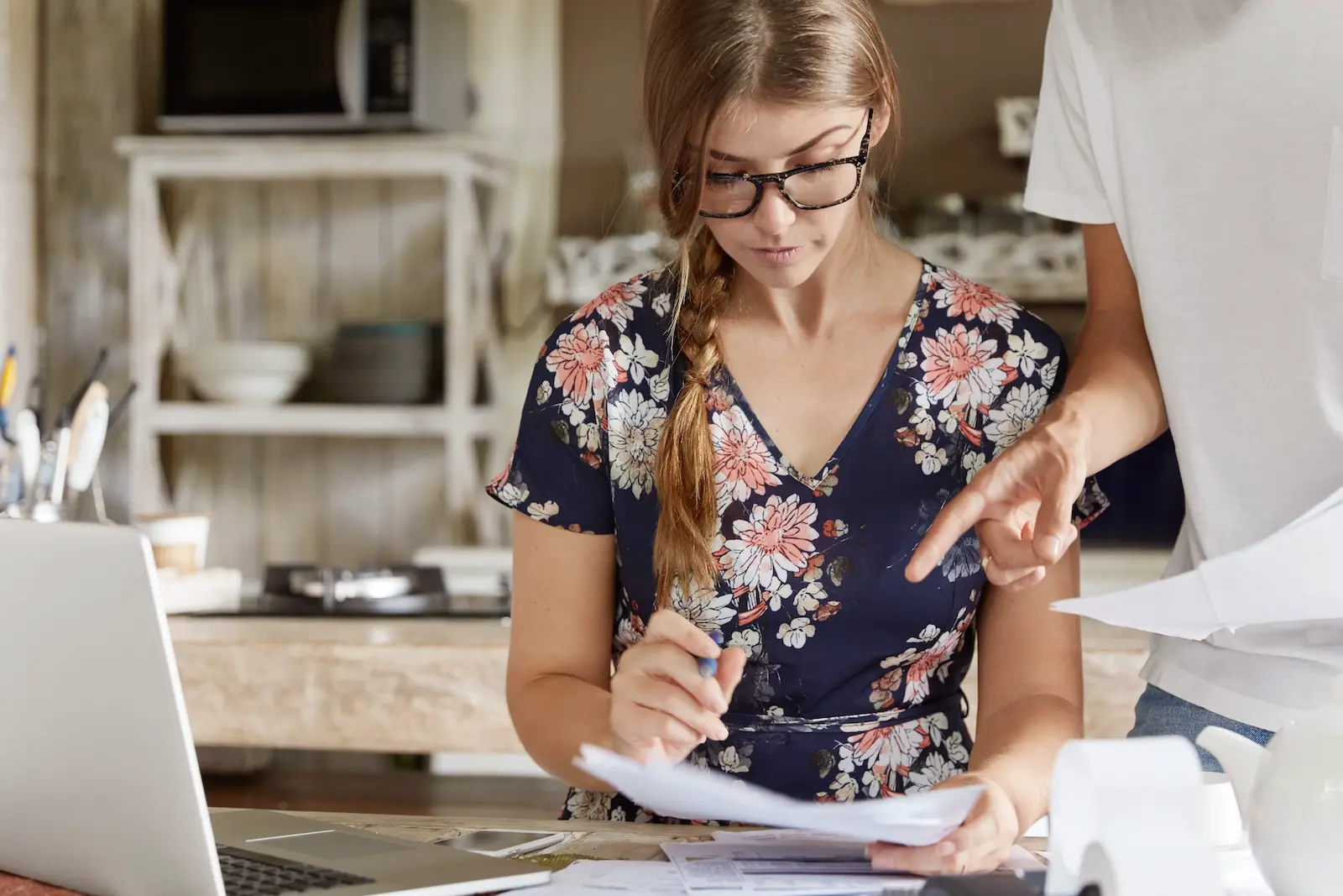 Shopify pricing – a store owner checking a receipt and her costs at a laptop