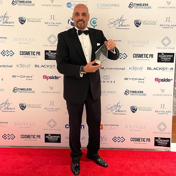 Dr Ash Labib holding award