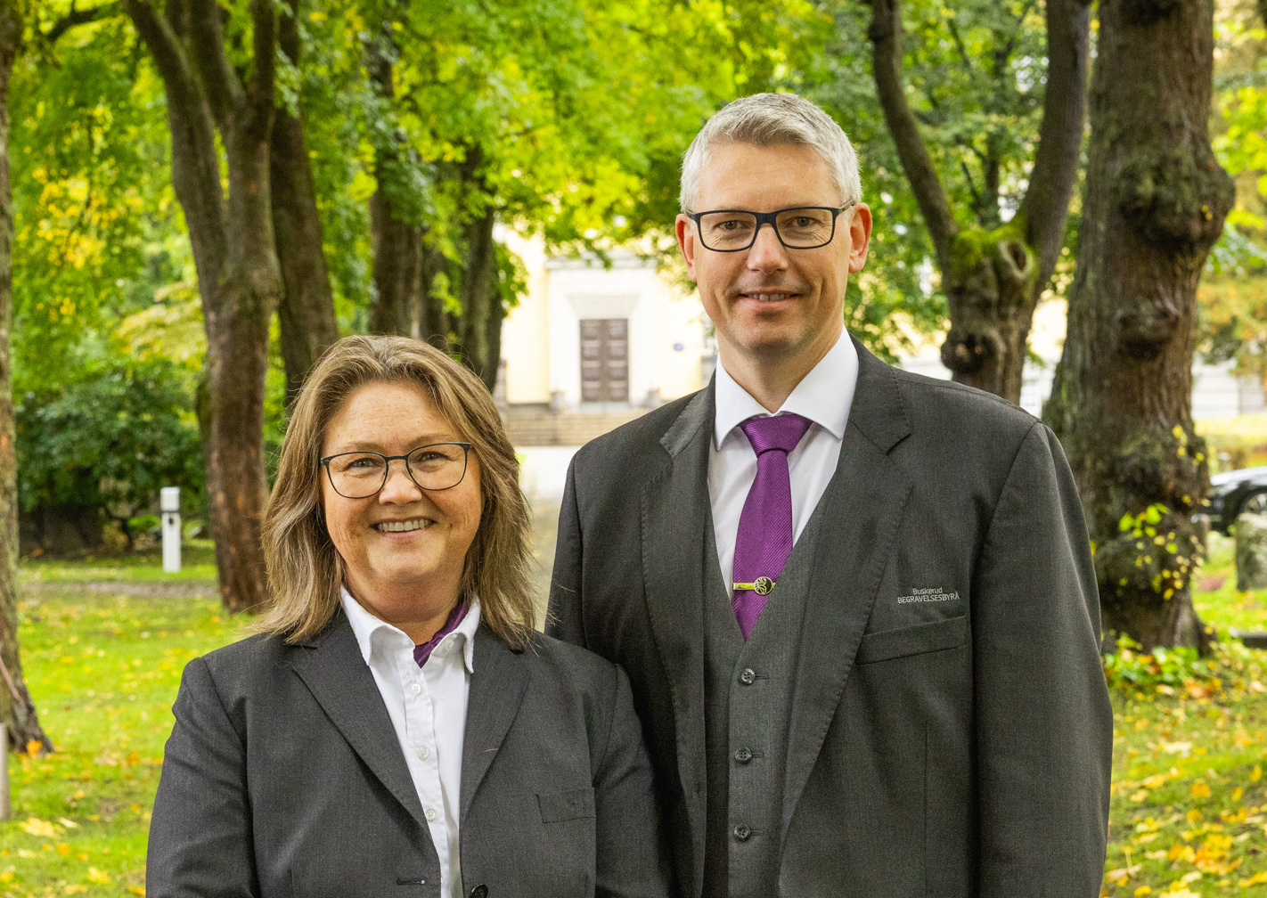Kvinne på en gravplass med hvit kirke i bakgrunnen