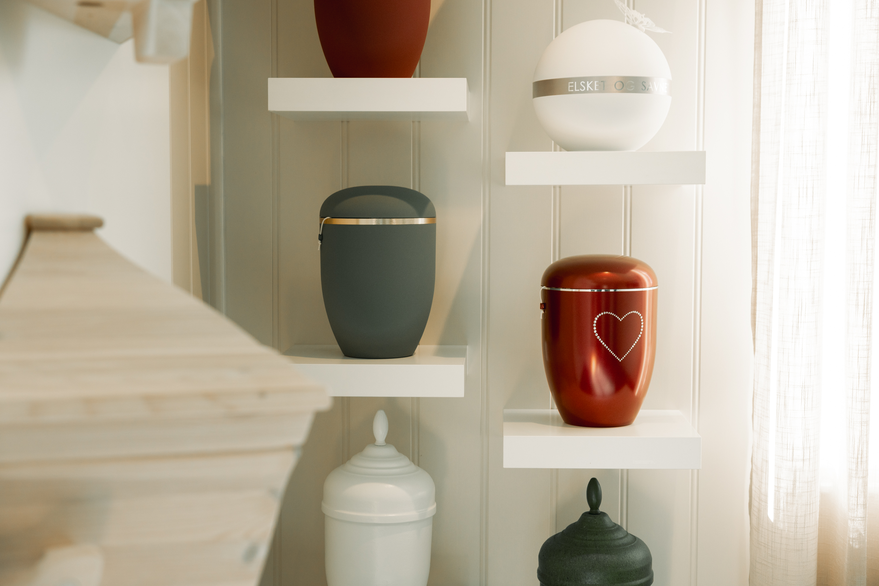 En hvit urne med blomster liggende rundt