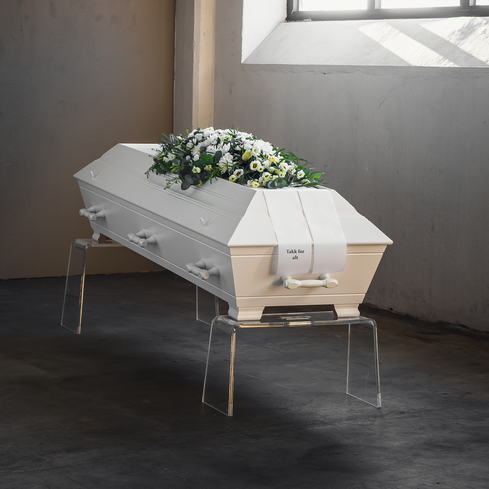 En kiste med hvite blomster liggende på toppen