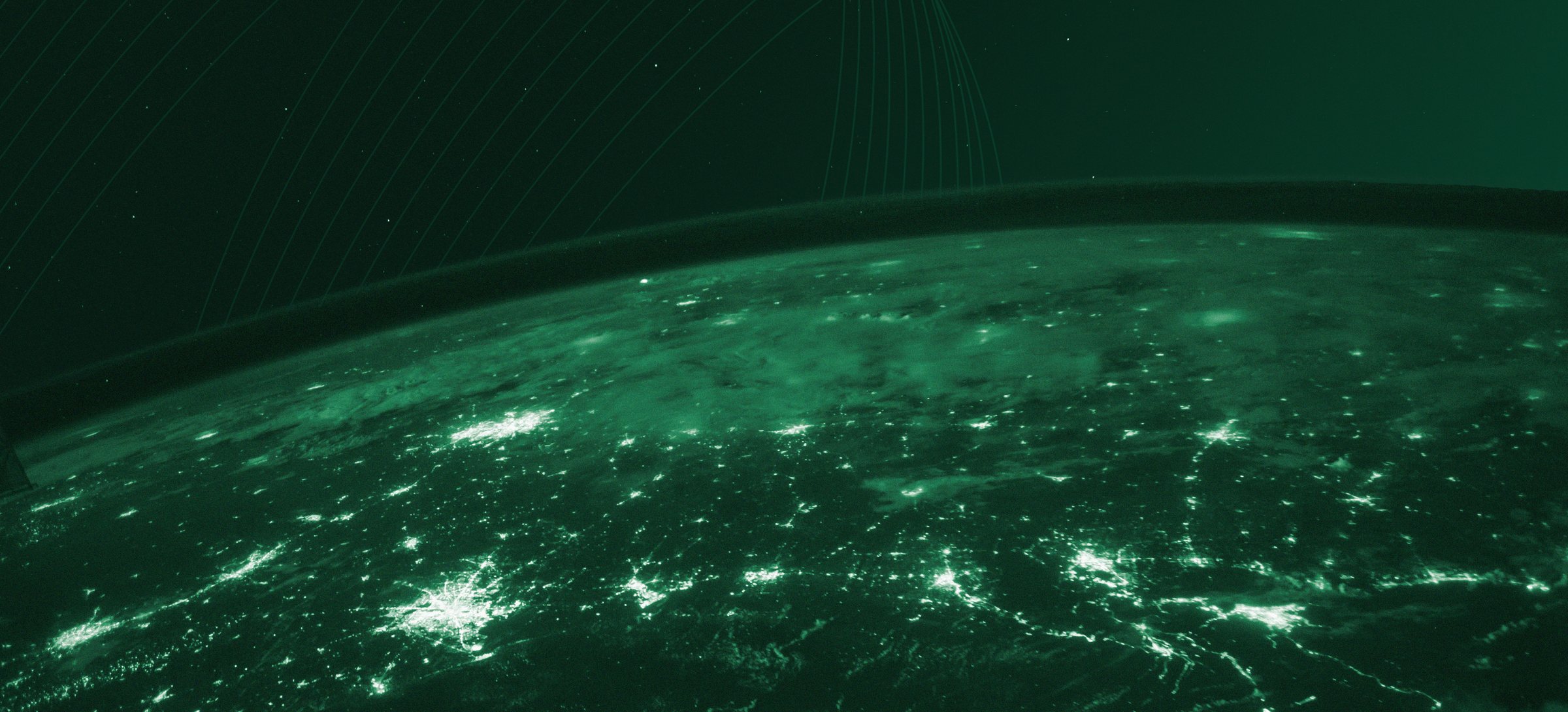 The curve of the Earth at night seen from orbit, city lights glowing across the continents, tinted in Loop green