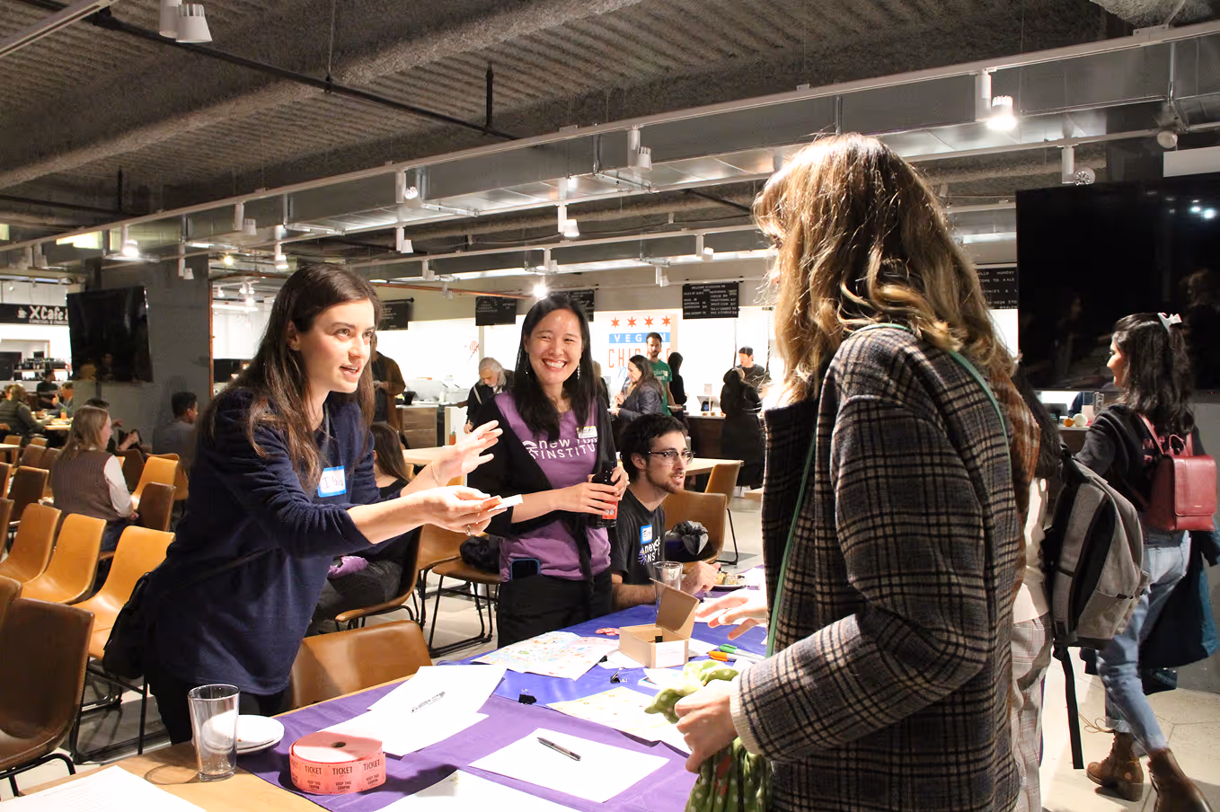 Fellow and staff engaging with the public across the table at an event.