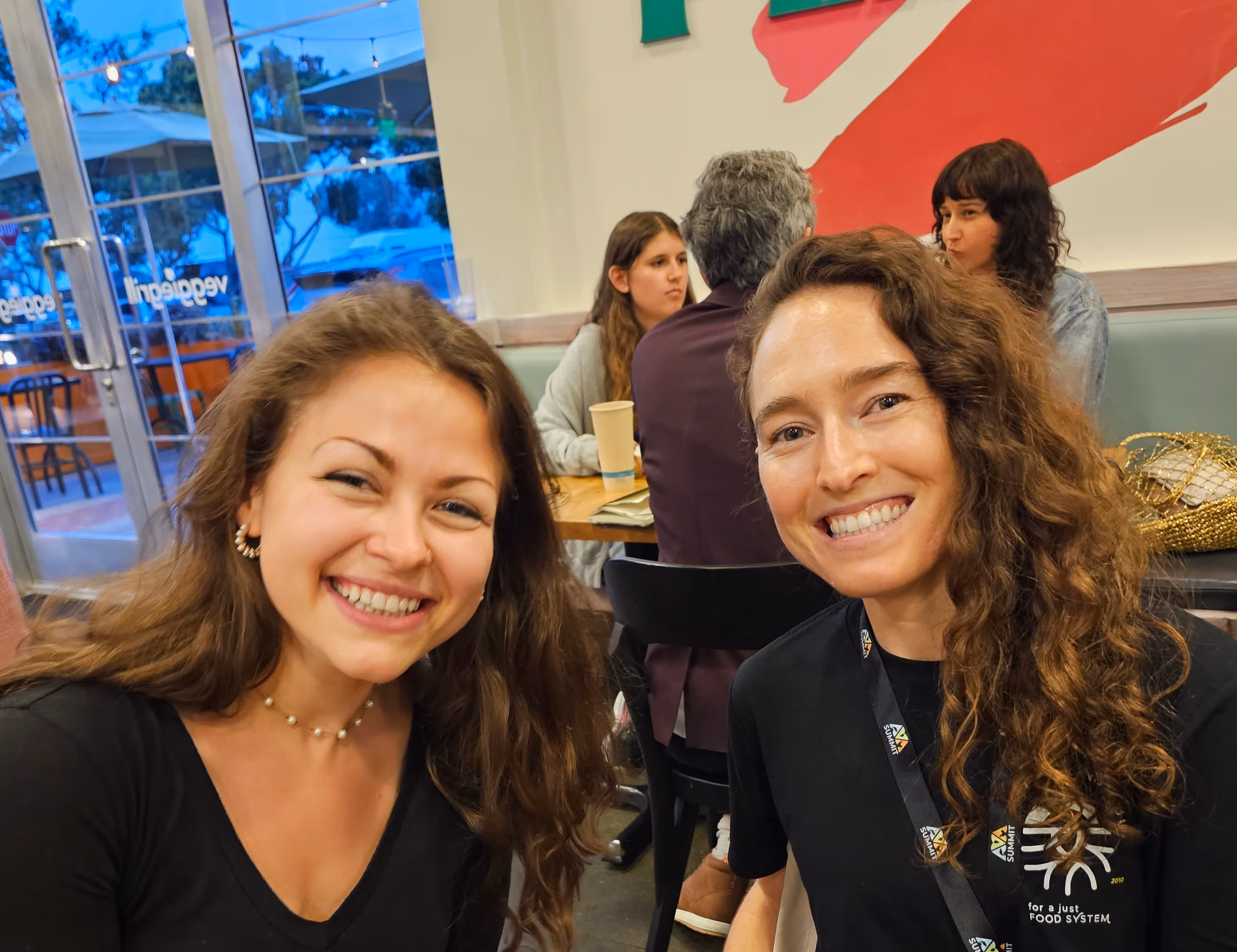 A fellow and a staff member smile at an event.