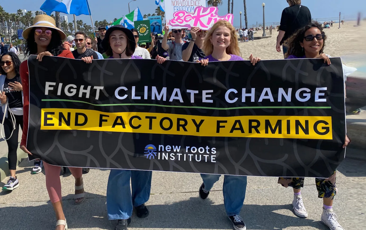 Fellows marching with a Fight Climate Change, End Factory Farming banner