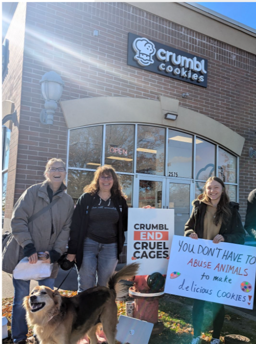 Angela and volunteers protesting for cage-free egg sourcing in front of Crumbl