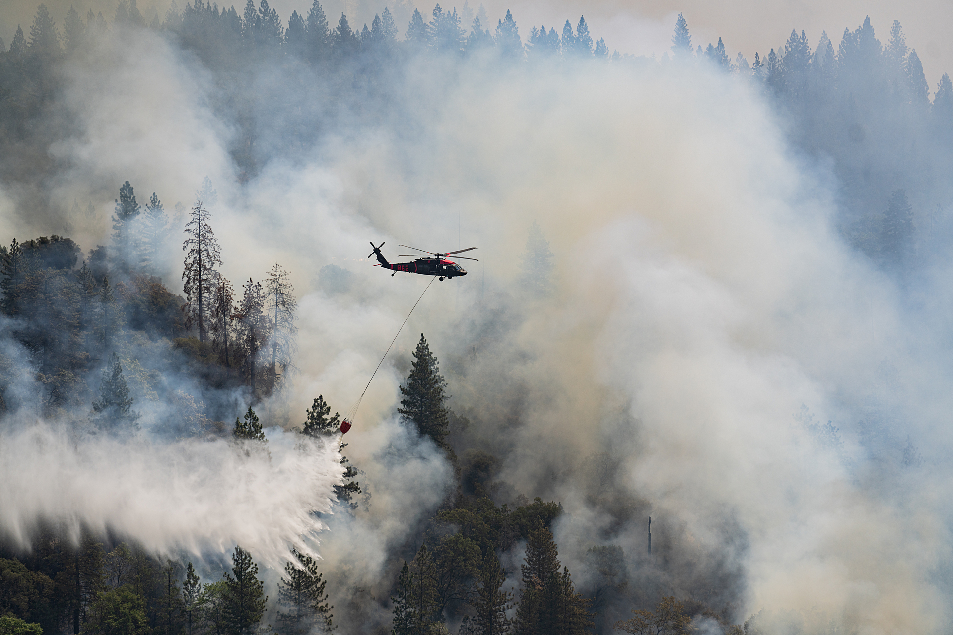 helicopter dropping water on wildfire in California