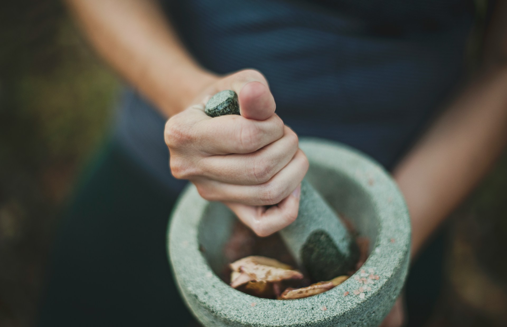 woman grinding with a mortar and pestle