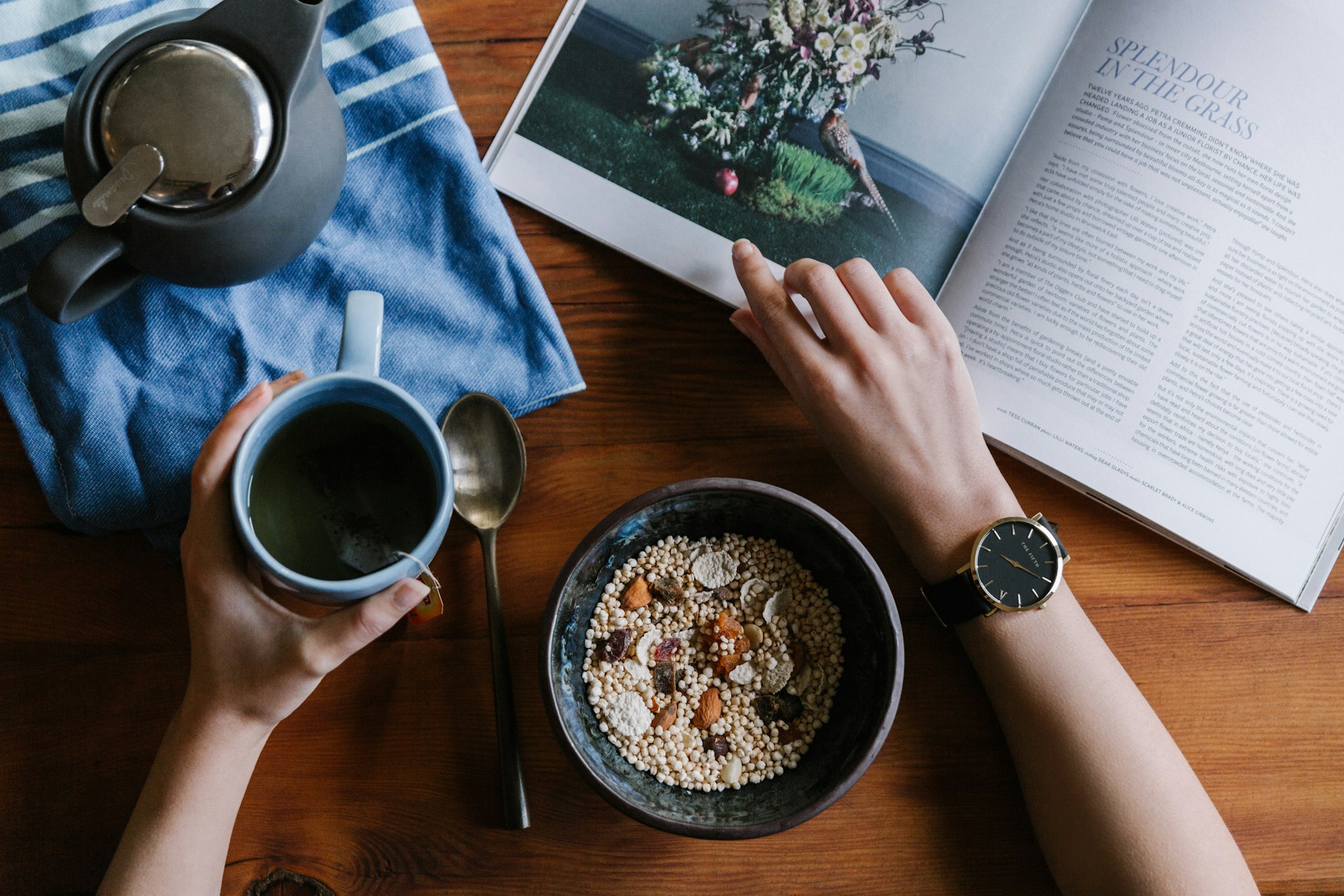 person reading magazine while eating breakfast