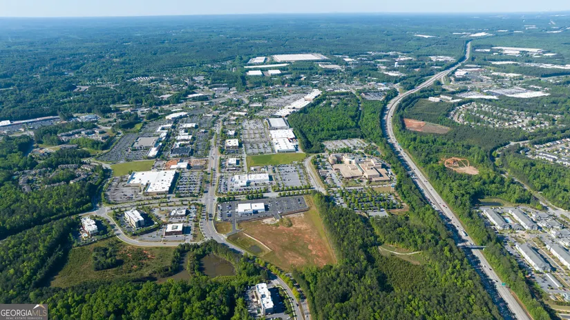 Aerial view of Newnan Crossing Bypass with roadway, nearby commercial development, and surrounding green space.