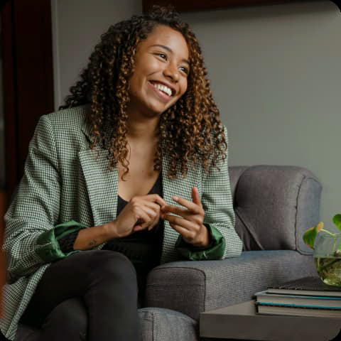 Provider smiling off to the side while sitting on a couch