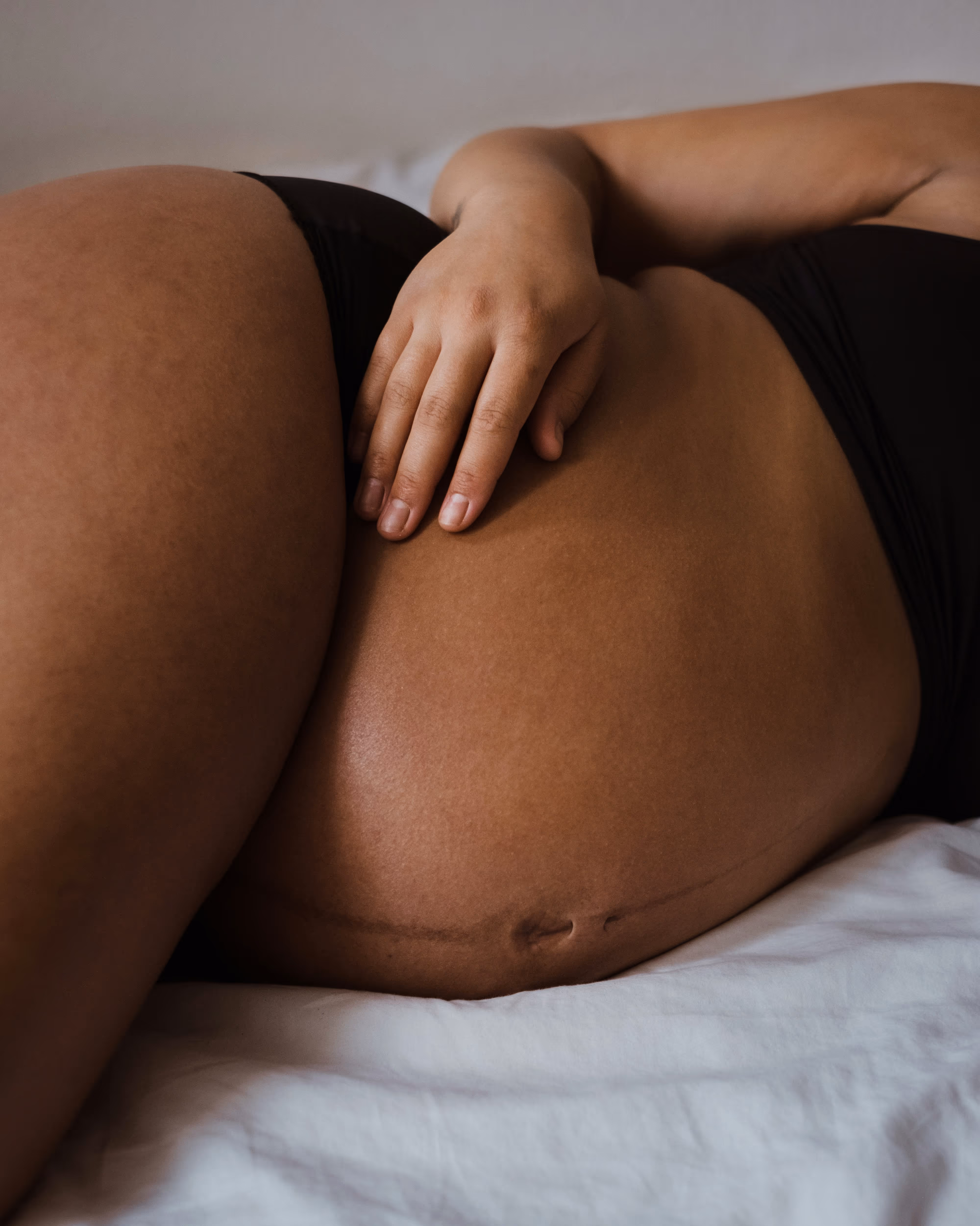 A labor and delivery RN smiles encouragingly while the birthing person pushes.