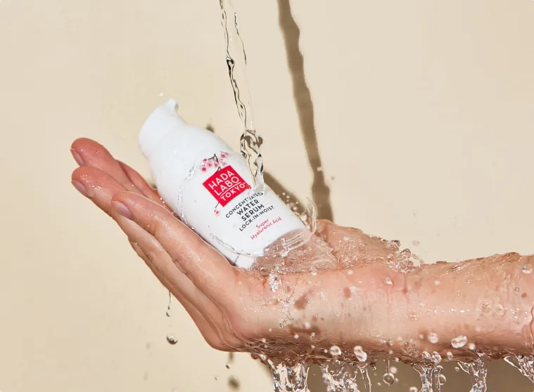 Hada Labo moisturiser in hand with water spilling over it