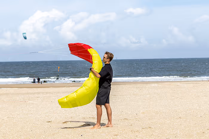 En mann holder en kite, som skal til å fly