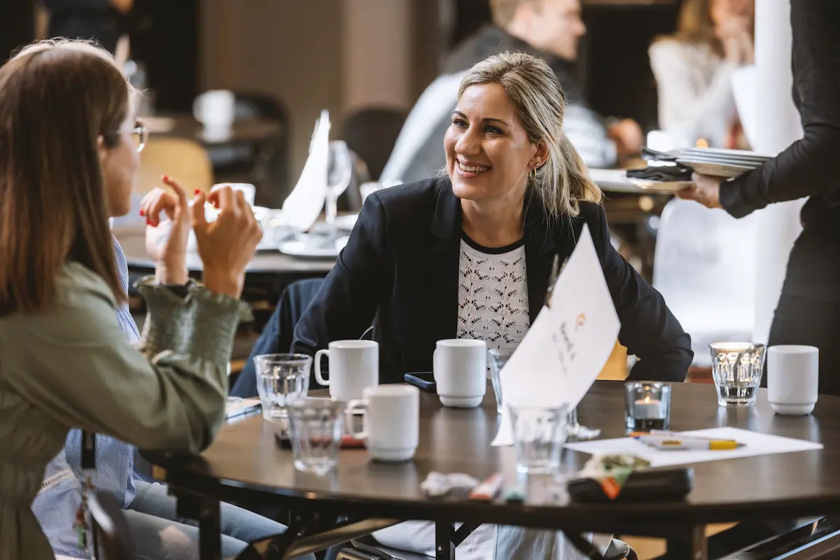 Smilende kvinne på konferanse