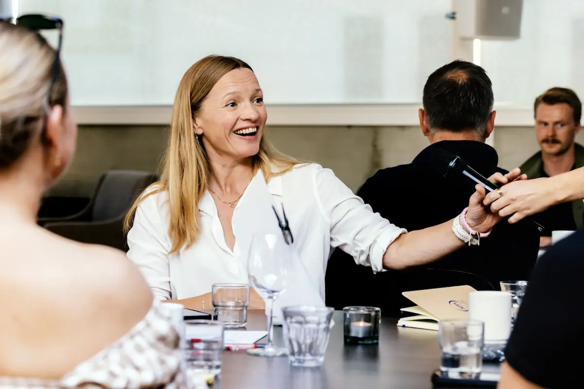 En smilende kvinne som tar imot en mikrofon