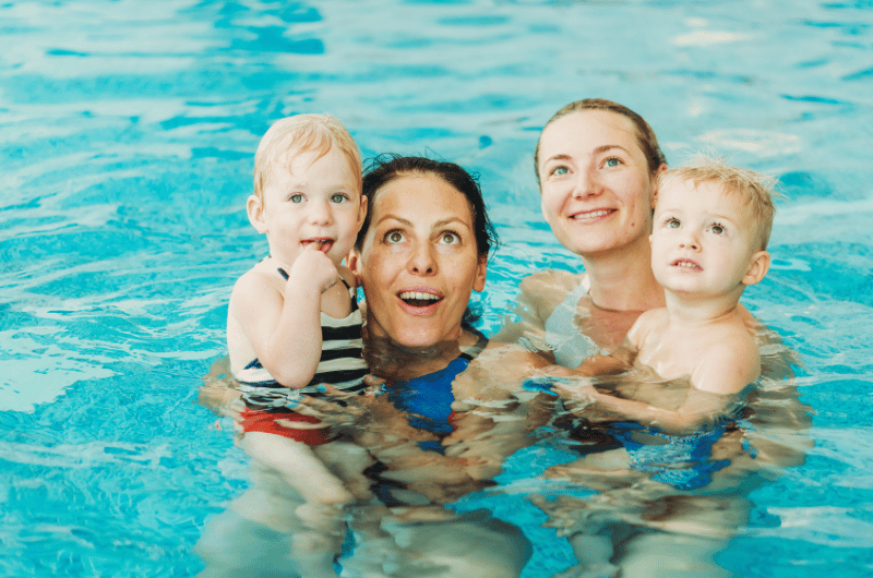 Zwei Mütter mit Kindern im Wasser