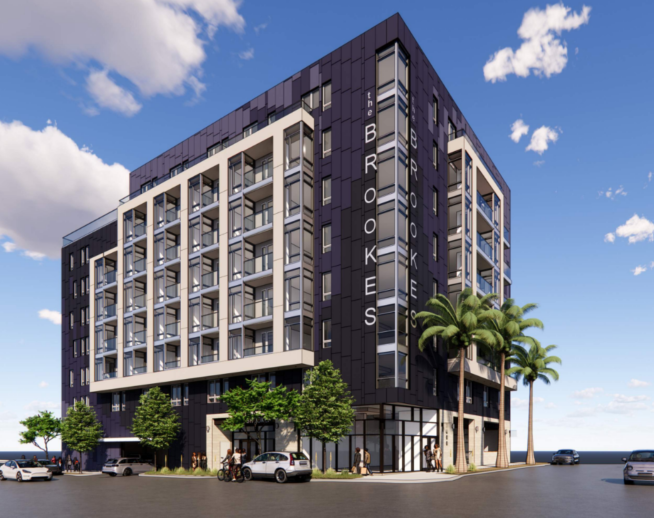Modern six-story apartment building with black and white facade, balconies, palm trees, and cars outside.