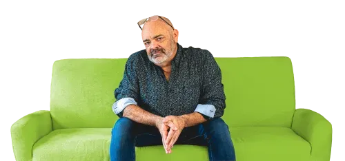 Rob Smith sitting on an electric-green couch, leaning over with arms resting on knees.