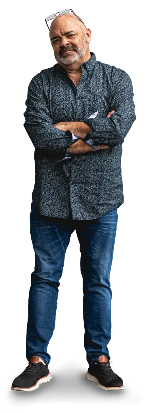 Rob Smith looking pensively, standing with his arms crossed, slightly leaning to the side.