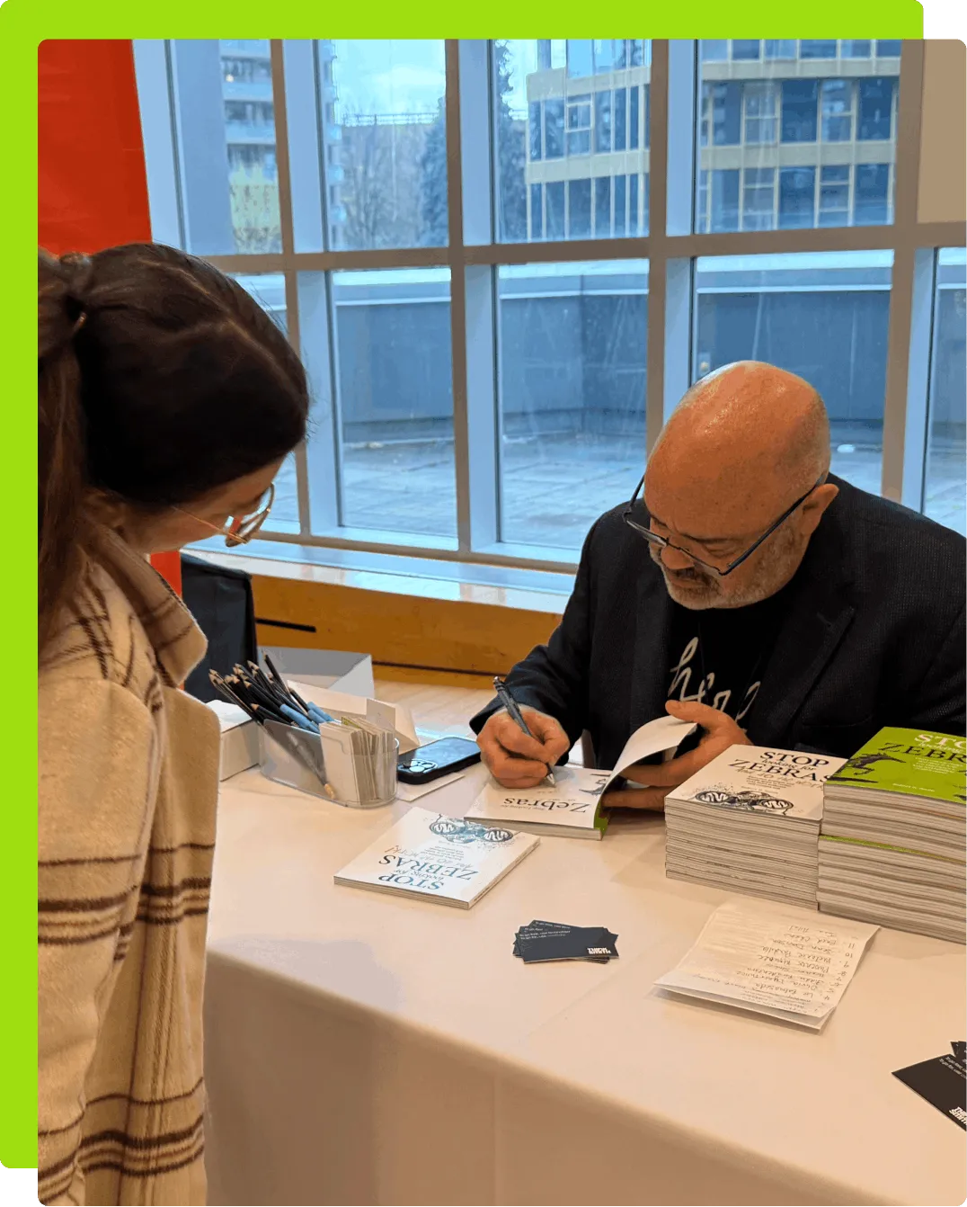 Rob Smith signing a copy of his book, 'Stop Looking for Zebras', for a someone.