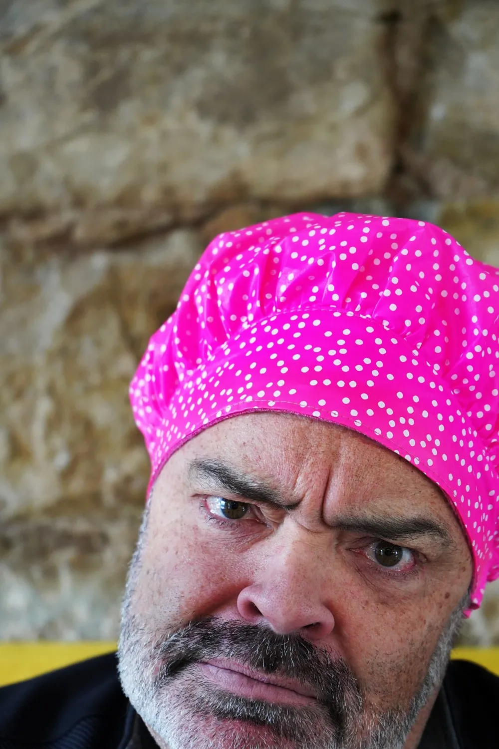 Close up of Robert Smith wearing the bright pink shower cap