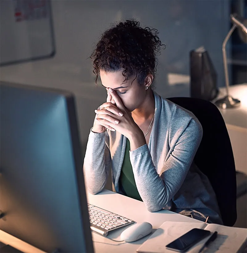 A stressed psychiatrist sitting at her desk trying to build her own website.