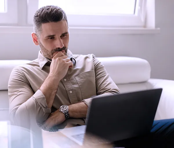 Pensive therapist looking at his laptop, starting to understand all the ways that his website can help his business