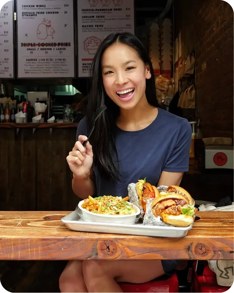 A woman sitting at a table with a plate of food.