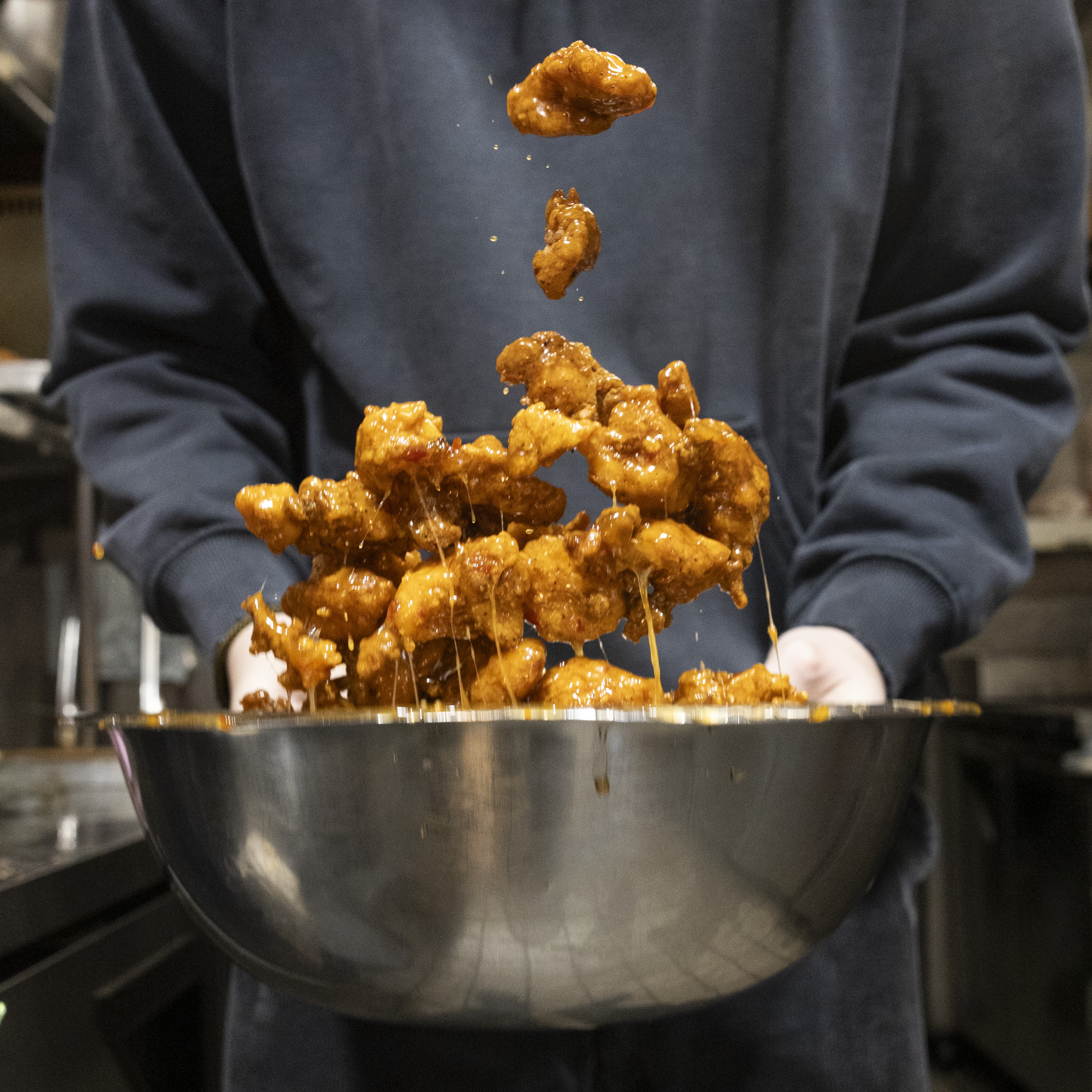 Chick 'n Pop being tossed in sauce