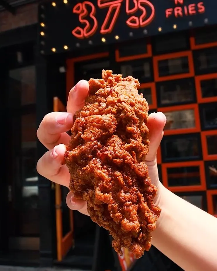 A person holding a piece of food in their hand.