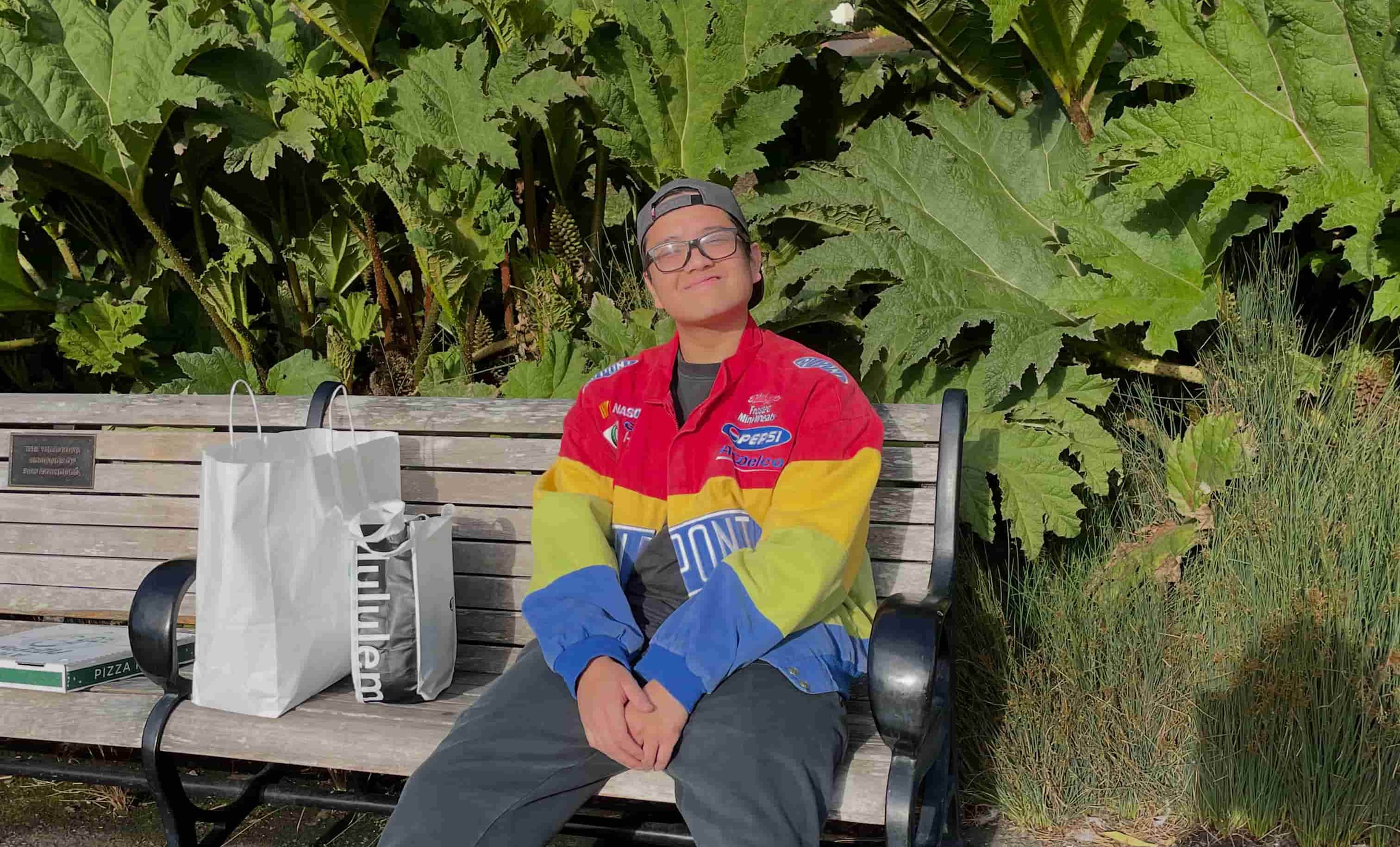 Santiago sitting on a park bench trying to look composed after eating too much