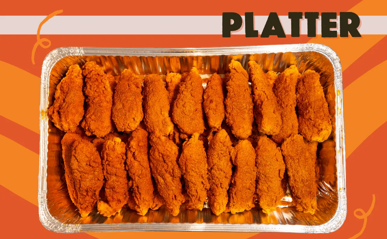 two trays of fried chicken next to a cup of orange juice