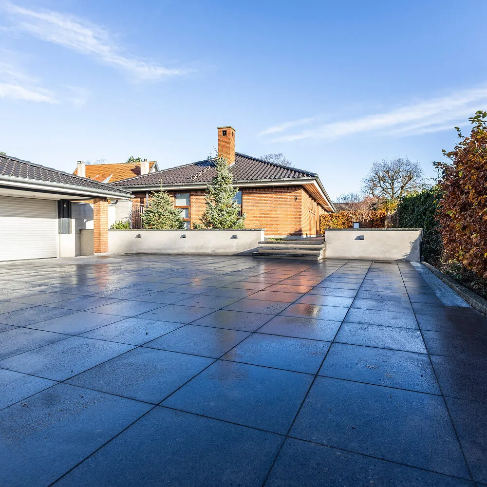 Stor nyanlagt indkørsel i Greve udført med mørke franske natursten.