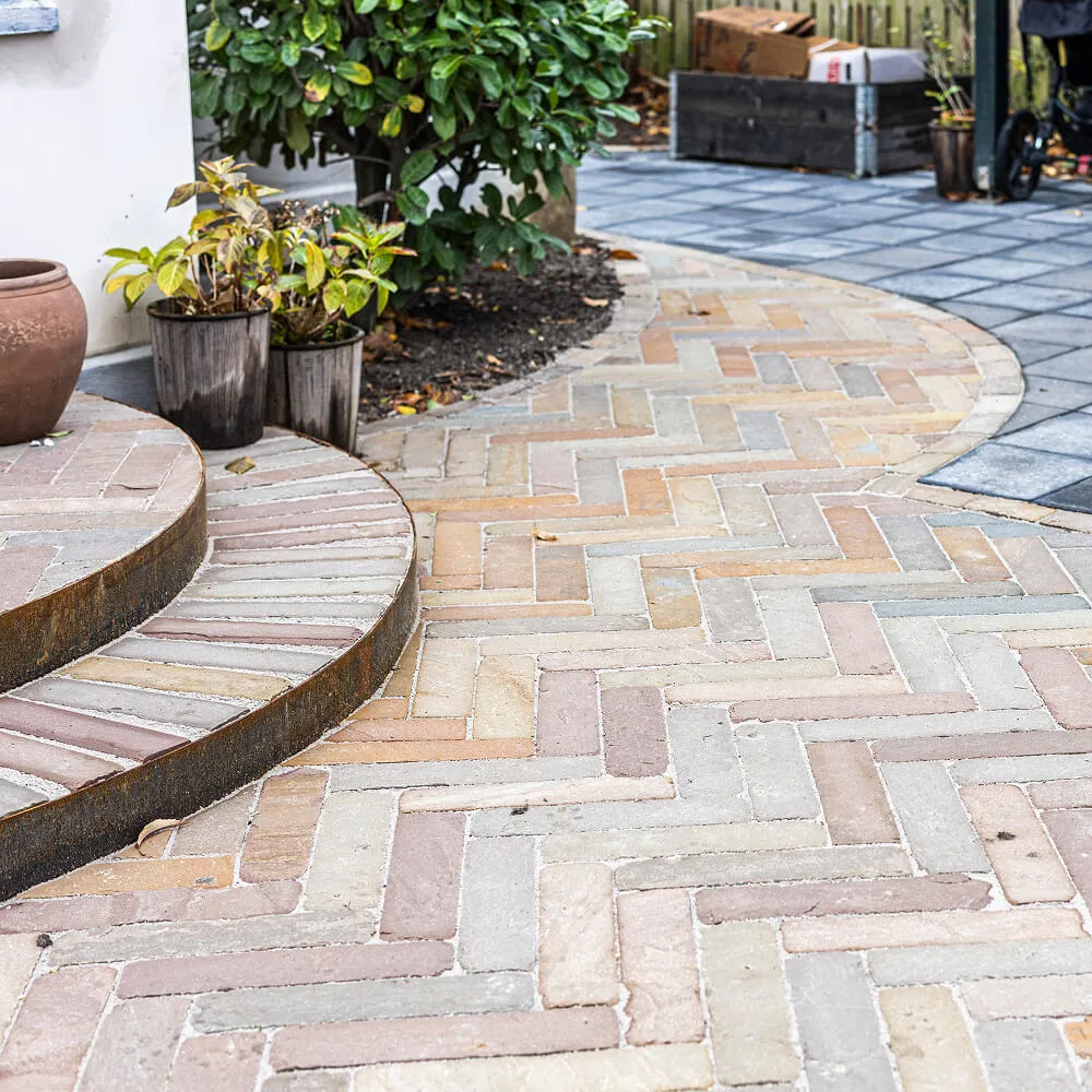 indgangstrin af natursten med sildebensmønster.