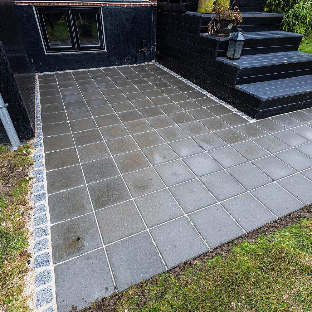 Brolægning omkring trappeparti og indgang.