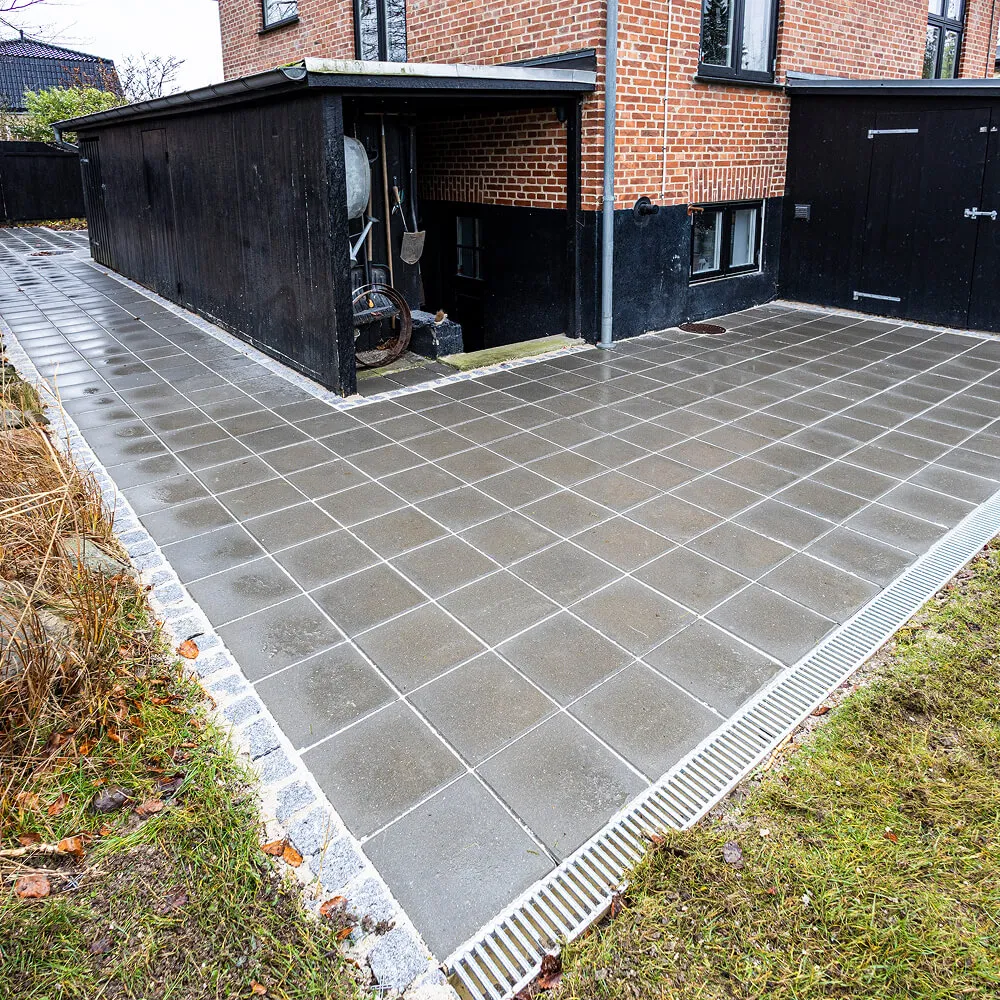 Langstrakt flisegang indrammet af klassiske chaussésten.