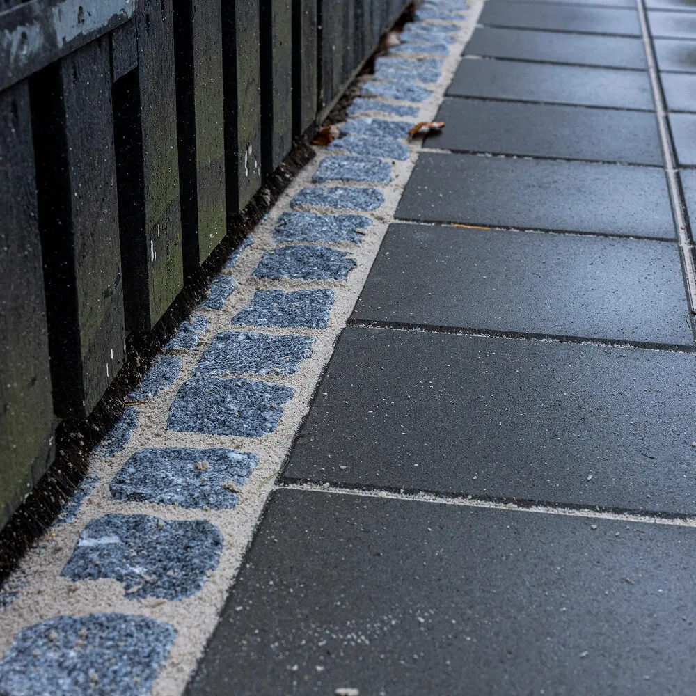 Langstrakt flisegang indrammet af klassiske chaussésten.