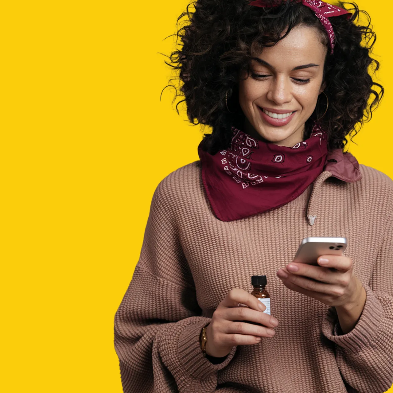 Well Revolution Unlimited Priority Member using a phone and holding a prescription medication